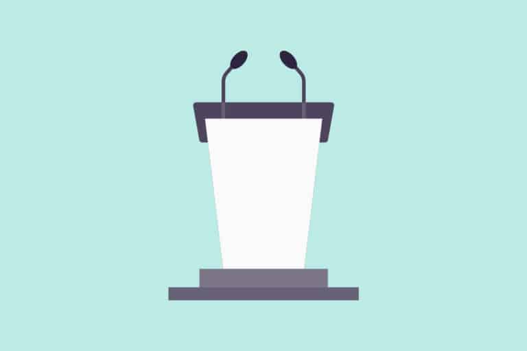 A blue podium with a microphone in front of a stage