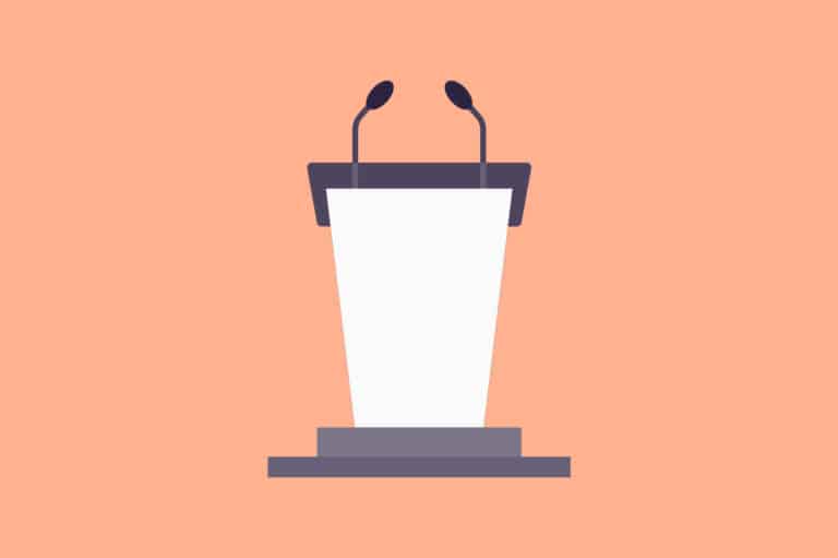 A peach-colored podium with a microphone in front of a stage