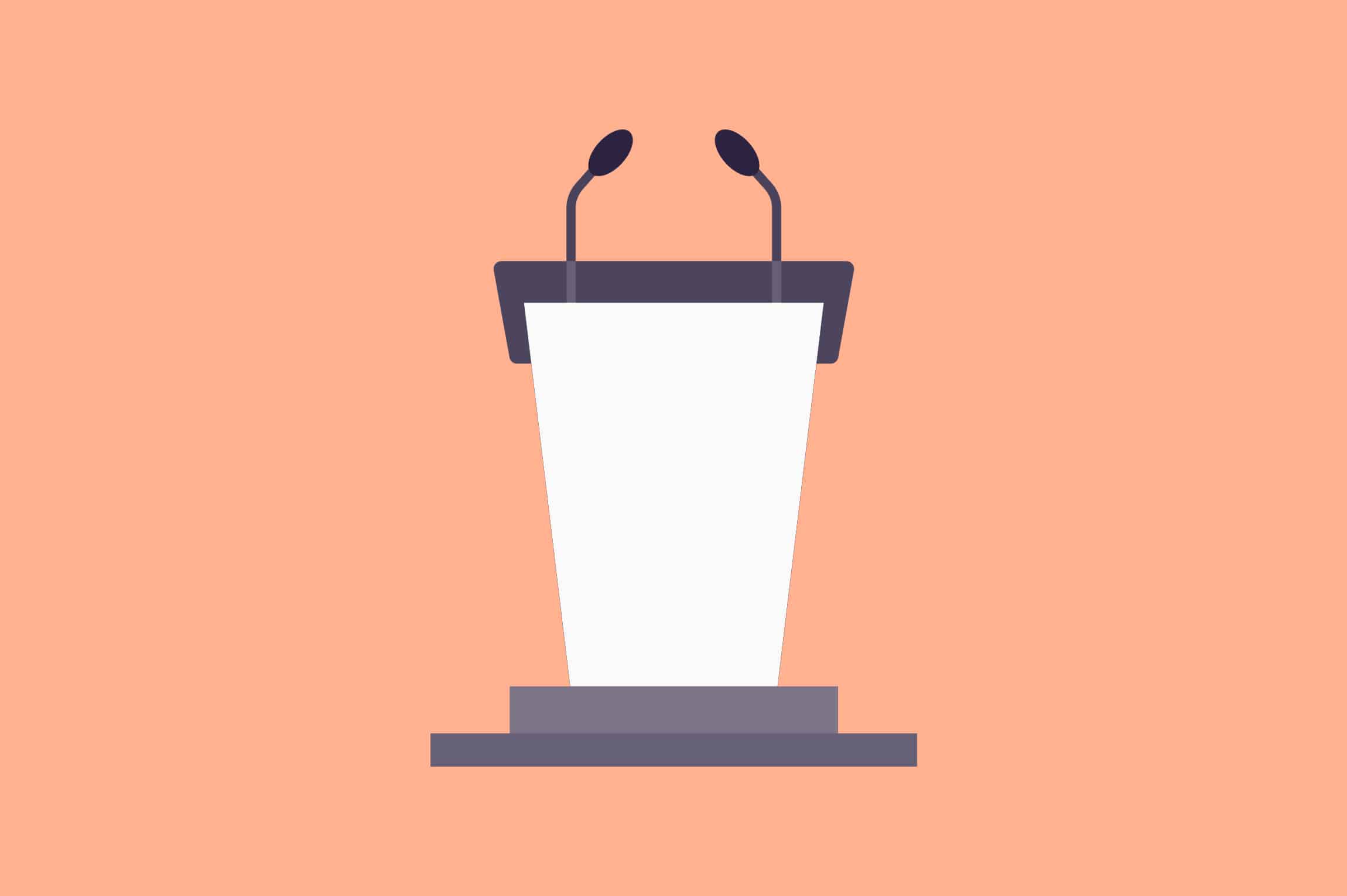 A peach-colored podium with a microphone in front of a stage