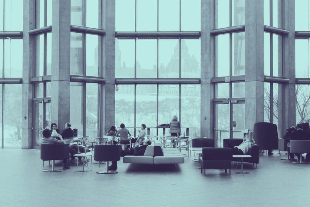 A group of people sitting in a building lobby
