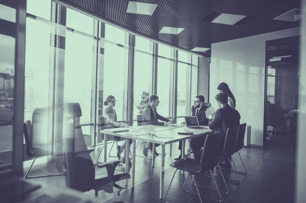 team in glass meeting room discussing how Climate Change Can Create Opportunities for Businesses to Thrive