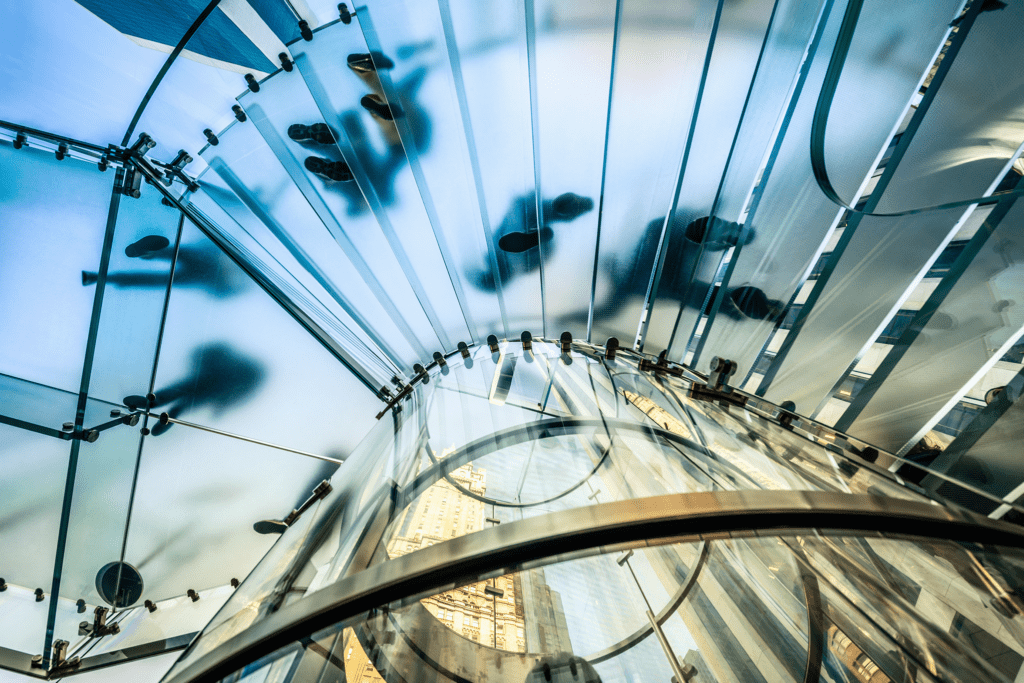 People walking on transparent glass spiral staircase in a futuristic building