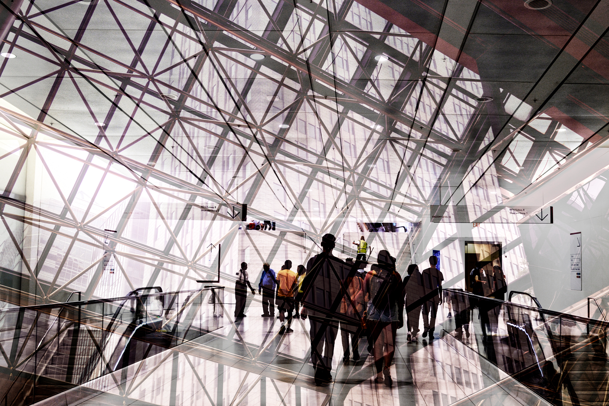 A group of people walking towards the escalators