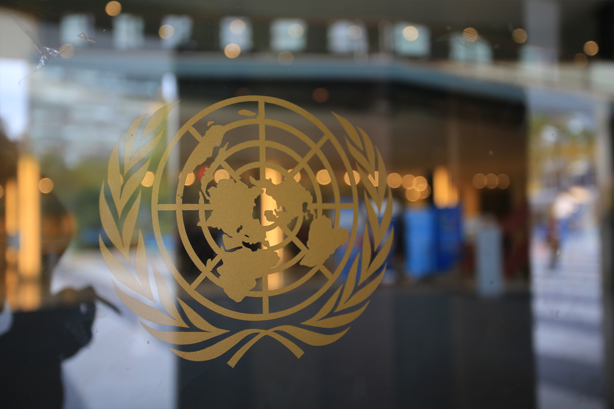 The United Nations logo in a glass wall
