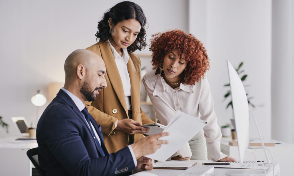 Employees gather around a desk